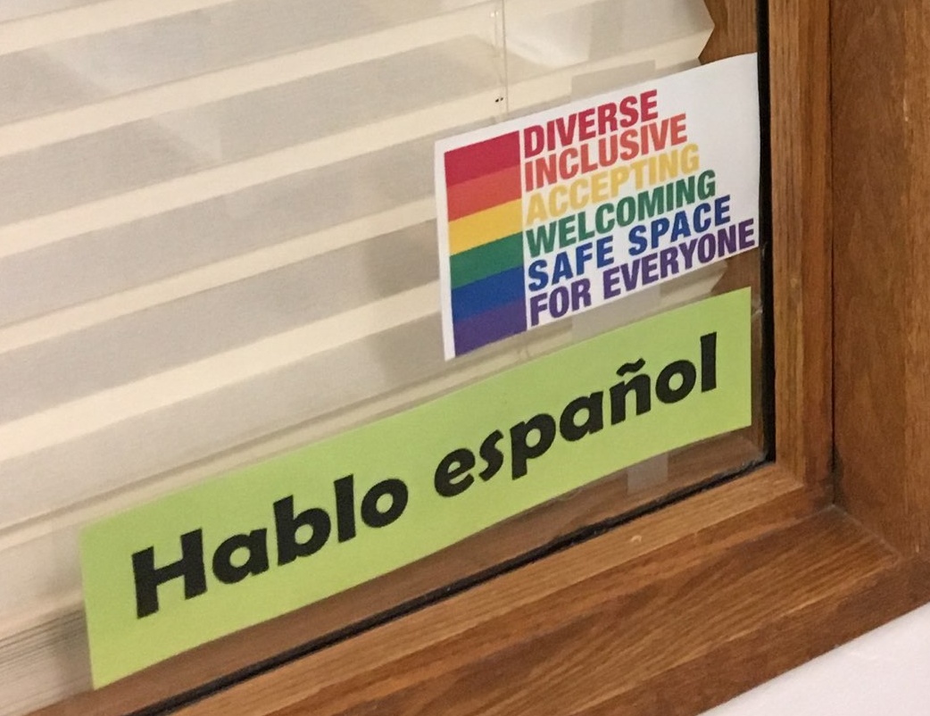 Sign posted on office window that says "Hablo espanol"