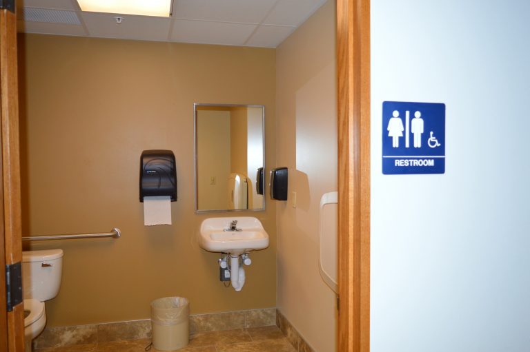 Library Accessibility: View of large single-stall bathroom with family restroom sign on wall near door