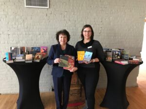 Two women stand in front of two tables piled with booksLynn Forseth and Angela Meyers with book donations for the Jefferson County Jail