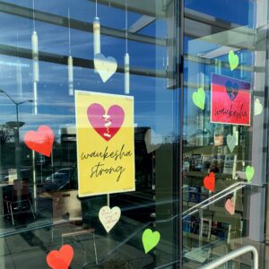 Heart ornaments and a sign in a window that says "Waukesha Strong"